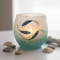 Strawsilk frosted glass aqua ocean fish votive tealight holder glowing warmly with lit candle inside
