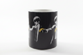 Banksy Pulp Fiction black ceramic mug on clean white surface, bright lifestyle product photography