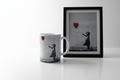 Banksy Girl with Balloon ceramic mug in bright lifestyle setting alongside Banksy artwork print
